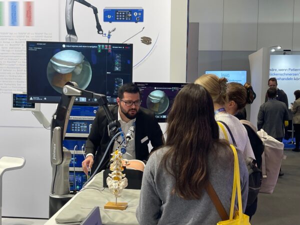 Joimax employee demonstrates the function of Robofix at the Joimax stand at the annual conference of the German Spine Society (DWG) in Hamburg.