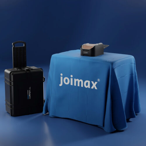 upsurgeOn 3D Illustration of a blue room with a table, a spine surgical training device and a black Box with the Upsurgeon Logo on it. The table is covered with a blue cloth with a joimax logo on it.