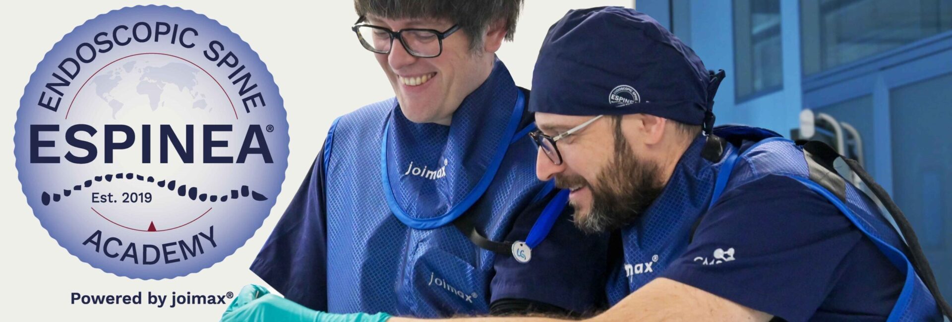 Two Surgeons in a endoscopic spine surgery education and training environment with the ESPINEA Logo in the Background