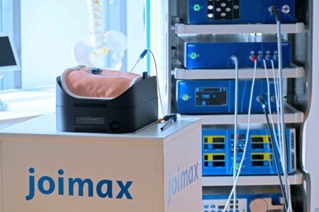 upsurgeOn lumbar spine model customized for joimax on a white table and a NAVENTO Tower in the background